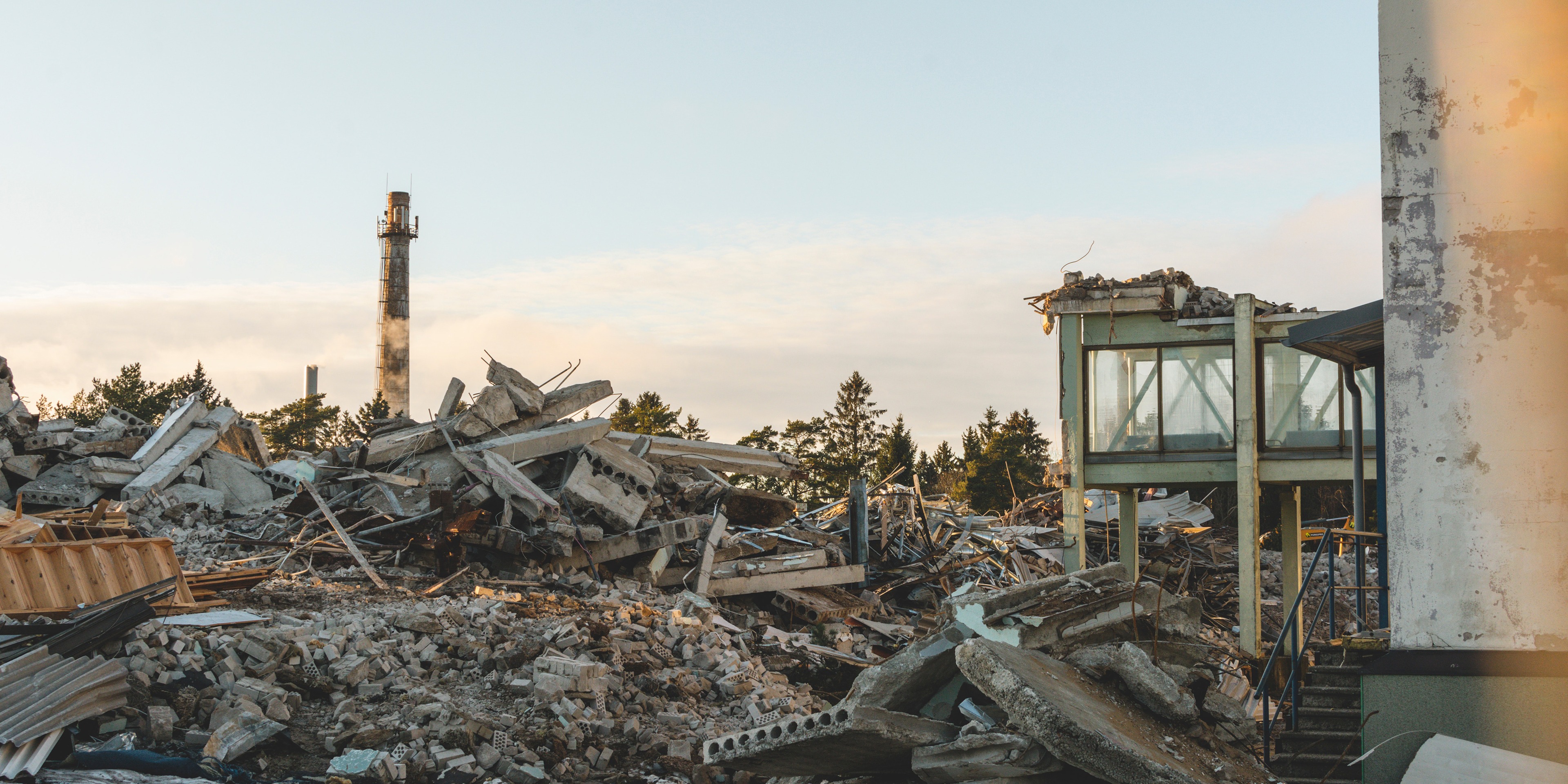 A pile of debris from a devastated building in an industrial area.