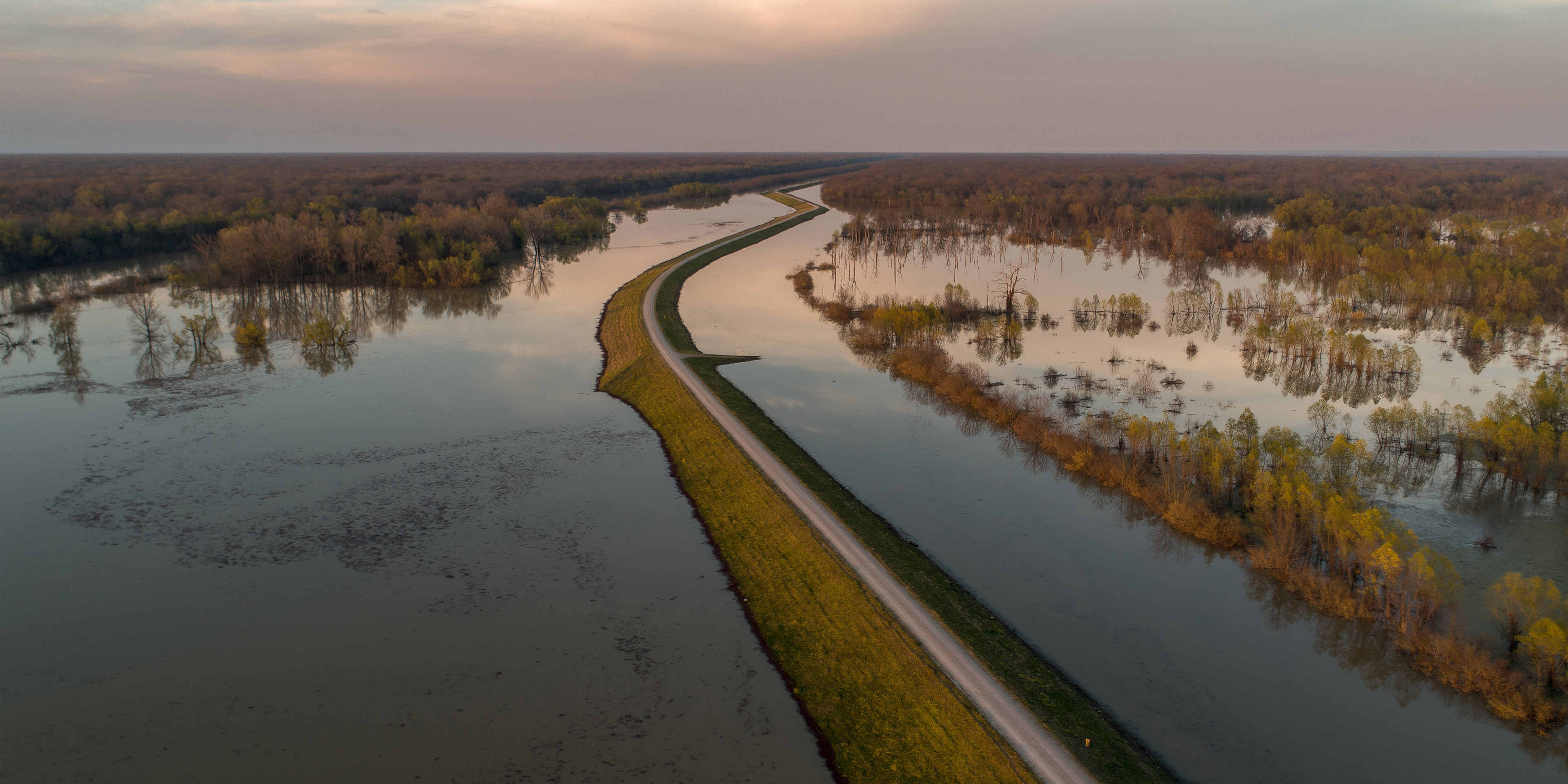 A landscape showing flooding around a levee that failed.